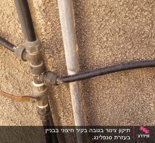 צינורות מחוברים לקיר עם ברז מתכת